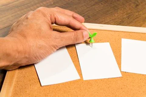 One left human hand pin blank white paper on cork board Foto stock