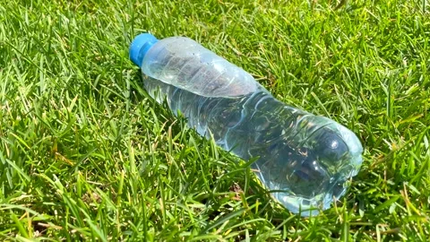 One litre plastic bottle of fresh clean water laying on green grass Stock Footage 185894623