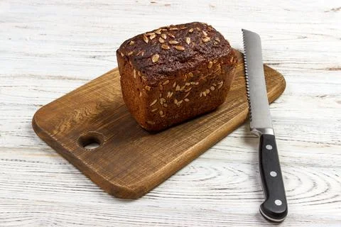 One loaf of bread on a cutting board with knife Foto stock