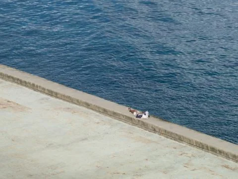 One lone man taking a break on the Malecon, Havana, Cuba Foto stock