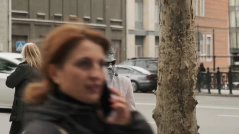 One made-up man with a gray face and hands is standing on the street Stock Footage 220738530