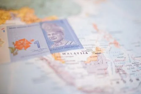 One Malaysian ringgit bill next to Malaysia on a colorful and blurry Asia map 스톡 사진