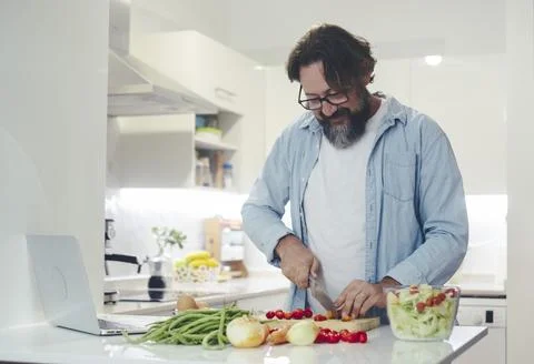 One man alone at home preparing lunch in the kitchen. Healthy lifestyle peo.. Stock Photos
