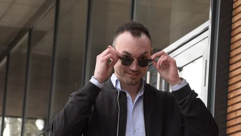 One man in a black jacket and sunglasses on the street Stock Footage 126552449