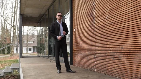 One man in a black jacket and sunglasses on the street Stock Footage 126553997