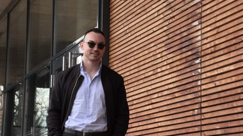 One man in a black jacket and sunglasses on the street Stock Footage 126555779