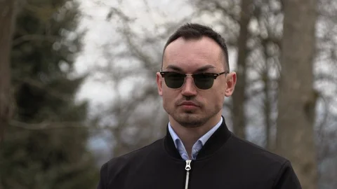 One man in a black jacket and sunglasses on the street Stock Footage 126556519