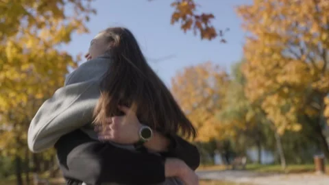 One man catching and spinning a happy woman in an autumn park cinematic style. Stock-Footage 332763980