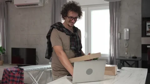 One man checking box of received package or product at home Video stock 249464484