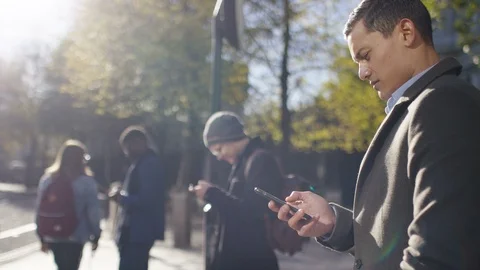 One man in the city using his phone as people move around him Stock-Footage 97976617