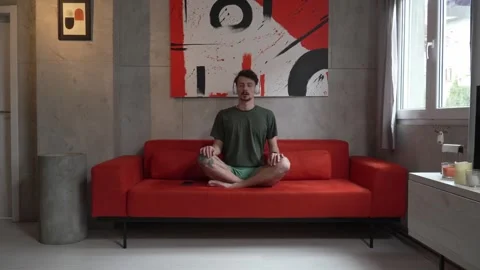 One man doing guided meditation yoga self care practice at home Stock Footage 242770562