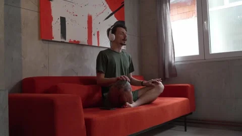 One man doing guided meditation yoga self care practice at home Stock Footage 242770630