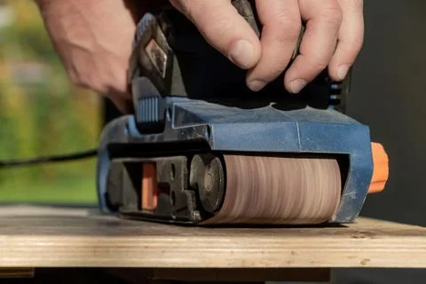 One man doing wood processing using a blue grinder machine Stock Photos