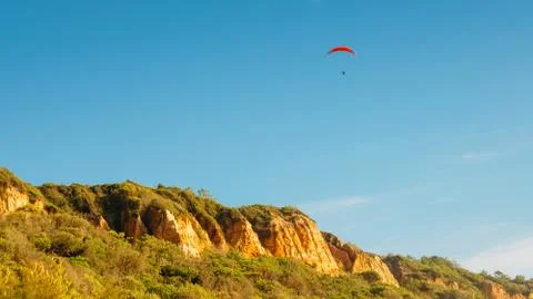 One man gliding using a parachute on the background of the blue sky Stock Photos