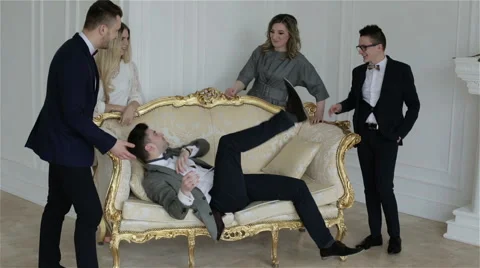 One man is jumping on the sofa. People are smiling and laughing. Vídeo Stock 61883771