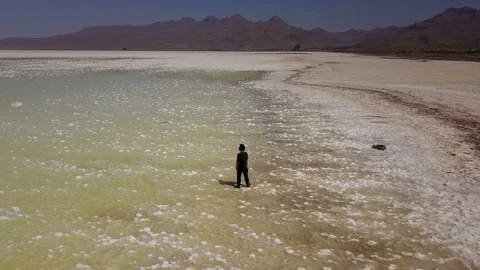 One man lonely on white Urmia salt lake in Iran Stock Footage 119896653