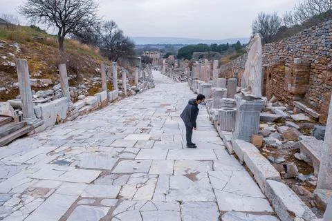One man with mask looking at statues on sides of Curetes Street in Ephesus ruins Stock Photos