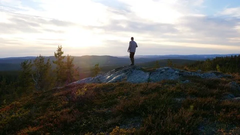 One man standing in the sunset on a mountain Stock Footage 98330419