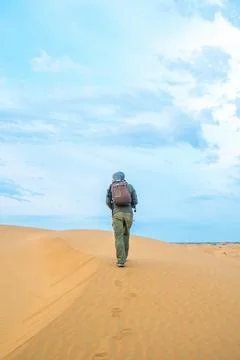One man stands on a sand dune in the Kyzylkum desert at sunrise. Stock Photos