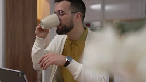 One man use digital tablet have video call online and hold cup at home Stock Footage 276477642