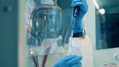 One man uses pipette while working with covid-19 antibodies in laboratory. Stock Footage 129520834