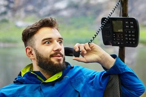 One man uses a wired push-button telephone. 写真素材