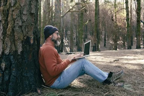 One man using phone cellular connection in a forest wood enjoying technolog.. Foto stock