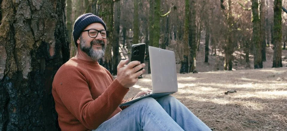 One man using phone cellular connection in a forest wood enjoying technolog.. Stock Photos
