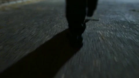 One man walking alone trough city park at night. spooky scary silhouette shadow Stock Footage