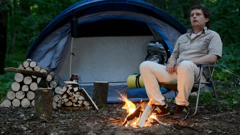 One man warms himself by the campfire outdoors. Stock Footage 92616195