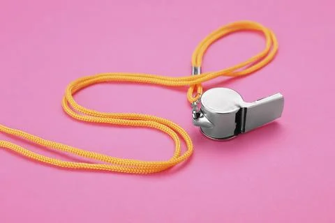 One metal whistle with cord on pink background Stock Photos