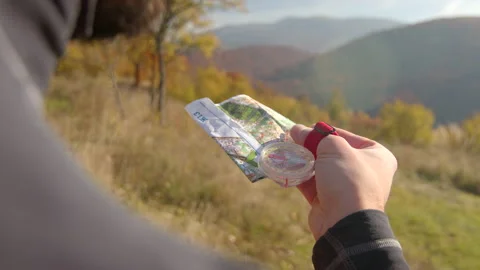 One mid adult looking into map for directions. Autumn hiking in forest. Sunny Stock Footage 166155904