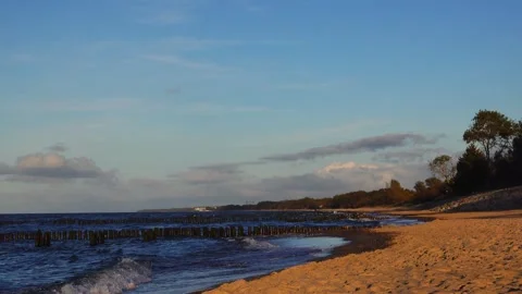 One minute 4k loop sea coast with wooden breakwaters on sandy beach and sooth Stock Footage 347199856