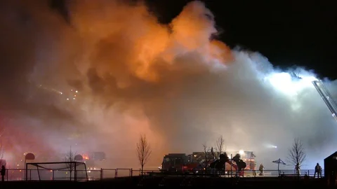One minute shot of massing ripping fire making firemen appear tiny Stock-Footage 129650024