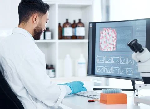 One mixed race scientist from the back analysing medical test samples and data Foto stock