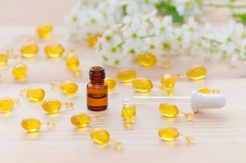 One ml brown bottle with neroli essential oils, a pipette, gold capsules of Stock Photos