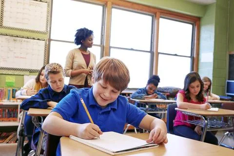 One more question to answer...a young boy sitting in class with his teacher and Stock Photos