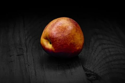 One nectarine green closeup black background Stock Photos
