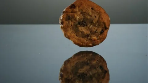 One Oatmeal Raisin Cookie Rolling Across A Dark Stock Footage 326291860