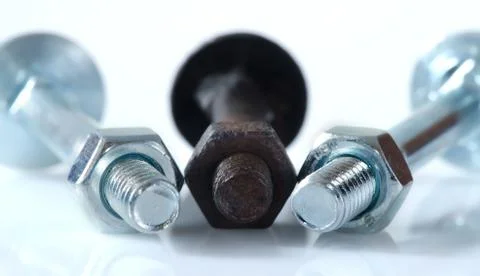 One old rusty screw among two new screws. Stock Photos