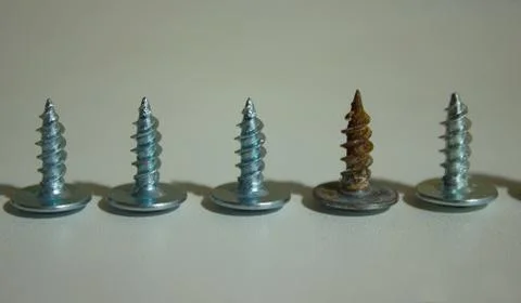 One old screw in a row of new screws Stock Photos