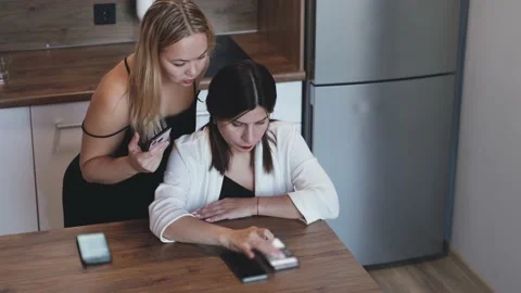 One on one meeting. Two young business women are sitting at a table at home. The Stock Footage 234215845