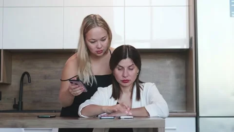 One on one meeting. Two young business women are sitting at a table at home. The Stock-Footage 234215870