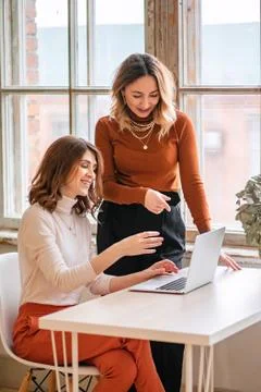 One-on-one meeting.Two young business women sit at a Desk in the office. The Stock Photos