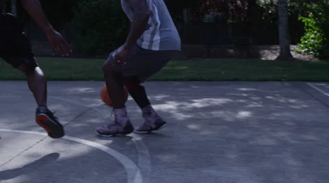 One on one street basketball; closeup on feet of player dribbling and shooting Stock Footage