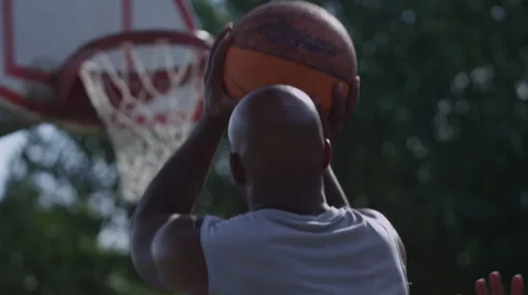 One on one street basketball; shoot and rack focus to hoop Stock Footage