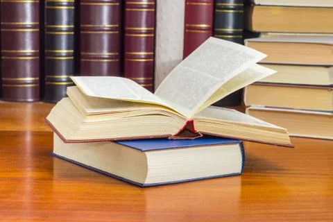 One open and one closed books against of other books Stock Photos
