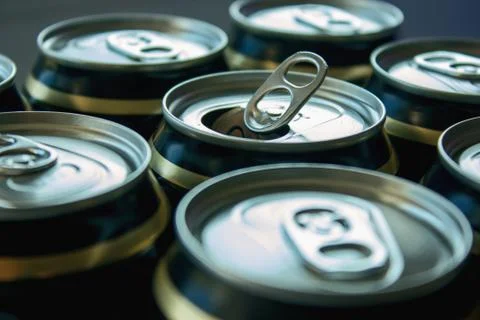 One open can for drinks among closed cans Stock Photos
