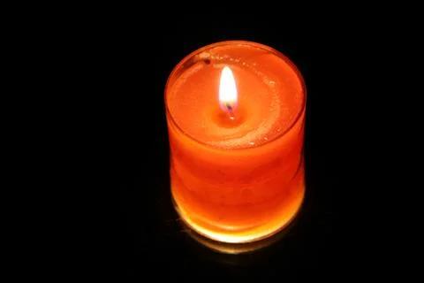 One orange Candle on black background and mirror reflection Stock Photos