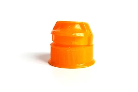 One orange cap from soft drink bottle on white background Stock Photos